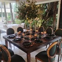 Montaje en mesa cuadrada con centros de mesa verdes